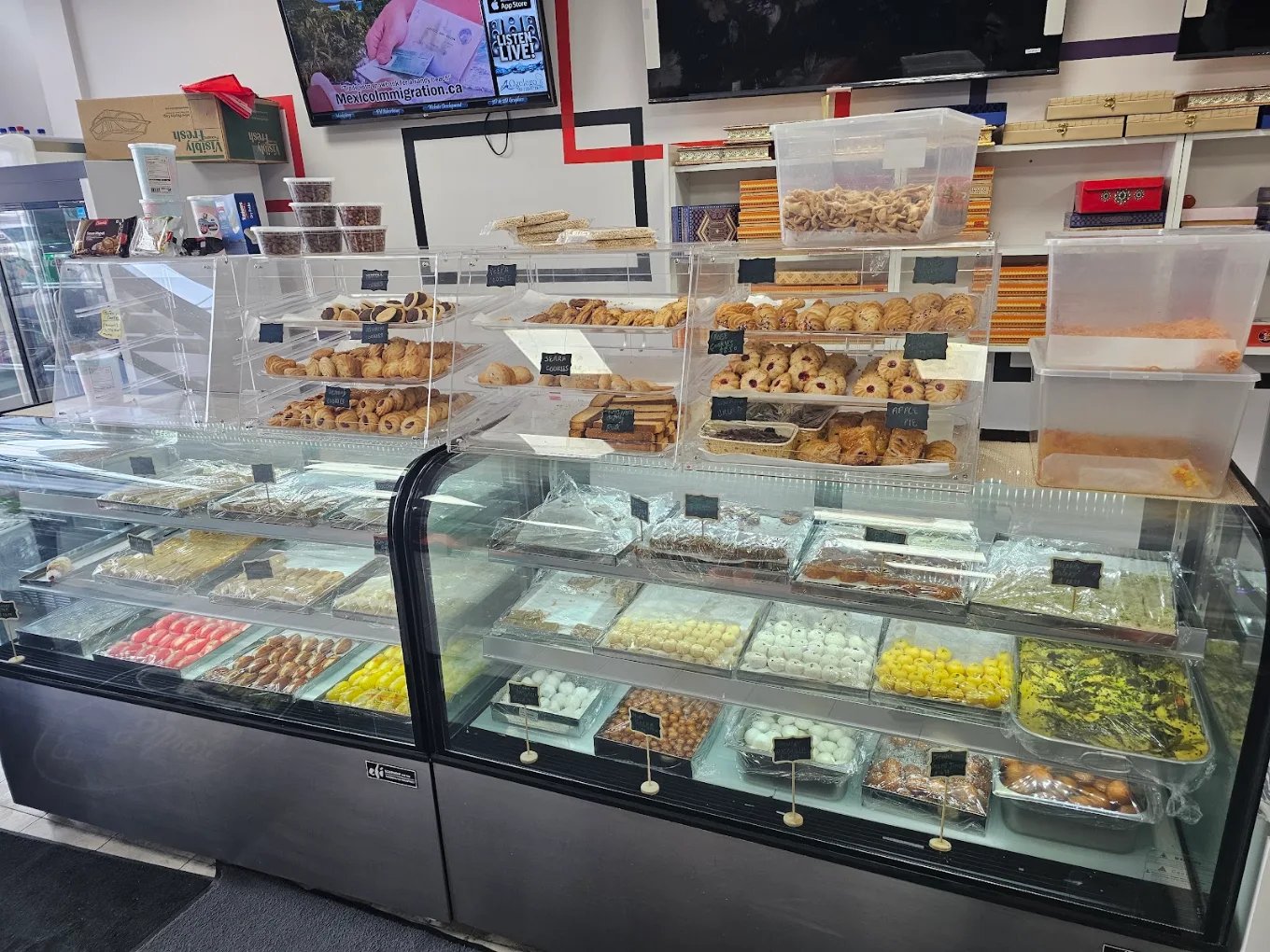 Bakery and mithai display cases full of pastries and sweets at Silver Spoon Edmonton