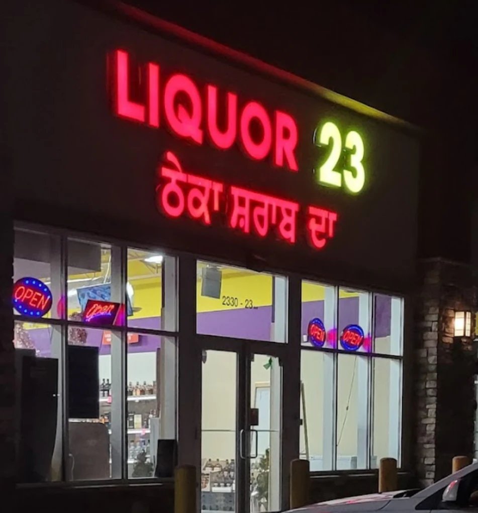 Liquor 23 illuminated storefront sign at night
