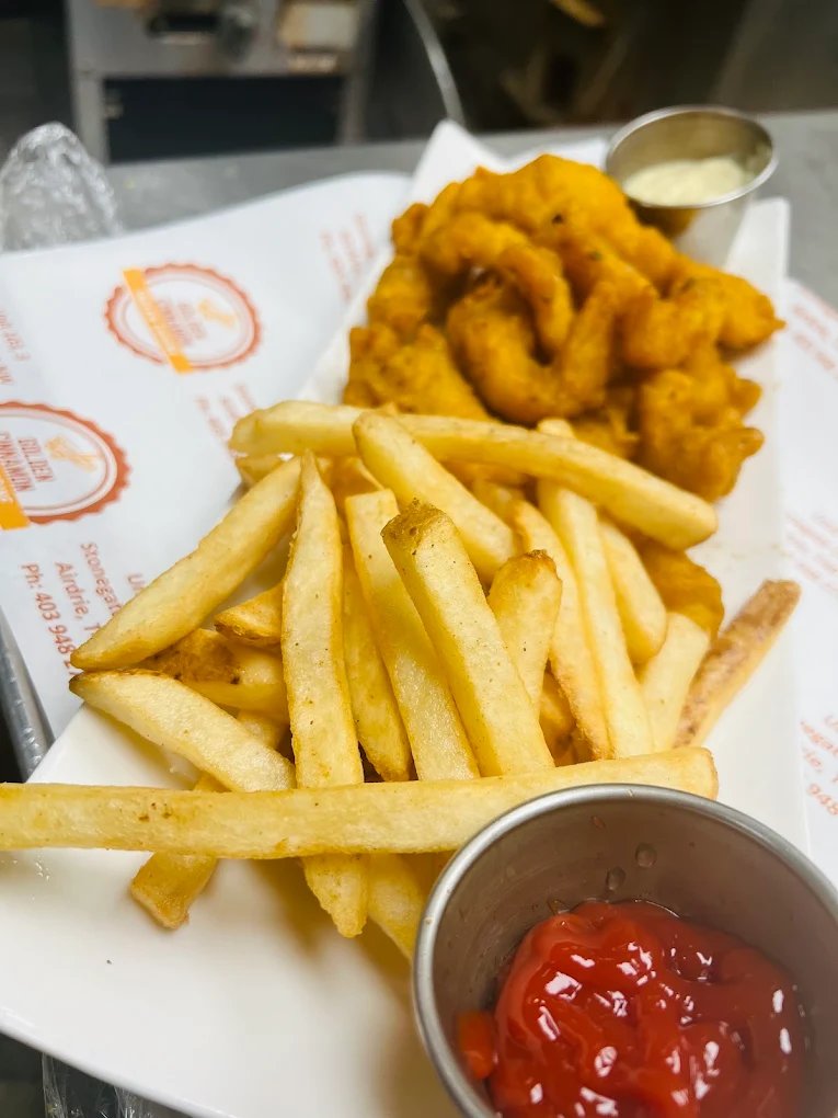 Golden fried fish and chips with tartar sauce and ketchup