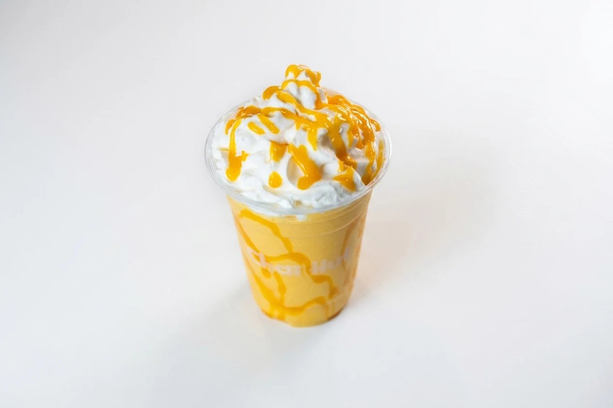 Mango shake with whipped cream and caramel drizzle