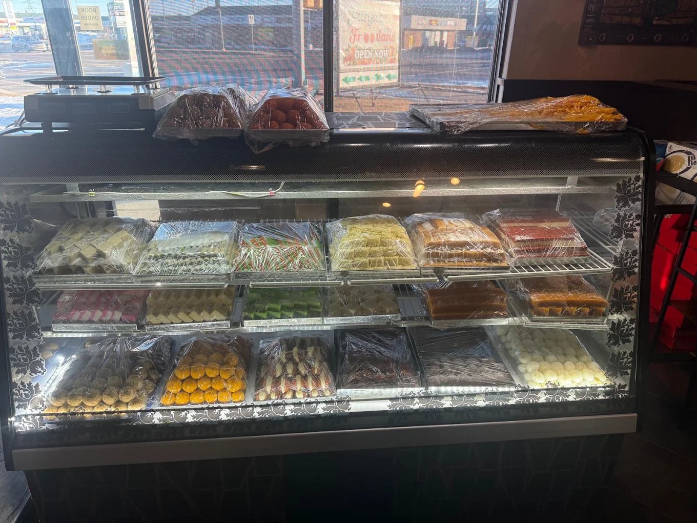 Display case filled with Indian sweets and mithai at New Asian Village Edmonton