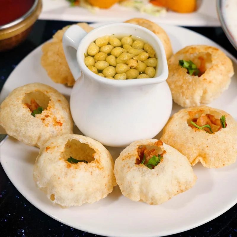 Pani puri with crispy puris and spiced water on a plate