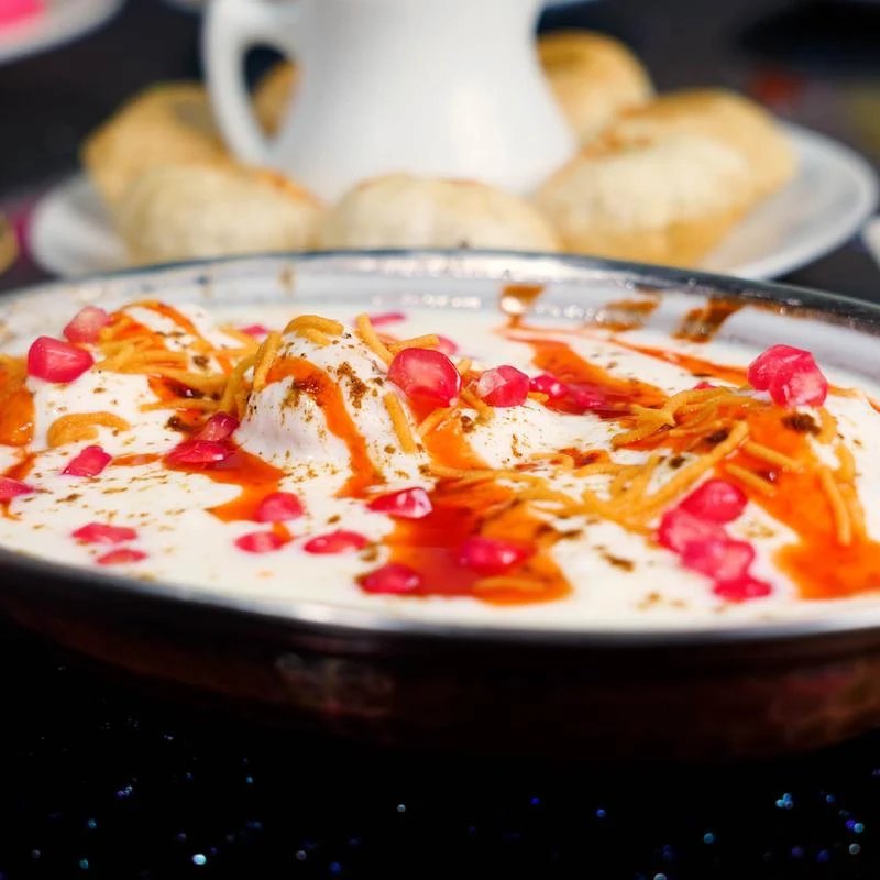 Dahi bhalla topped with yogurt, tamarind chutney, sev and pomegranate