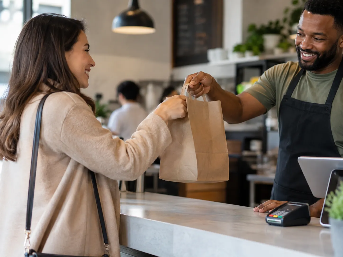 Restaurant owner handing a takeaway order to a customer