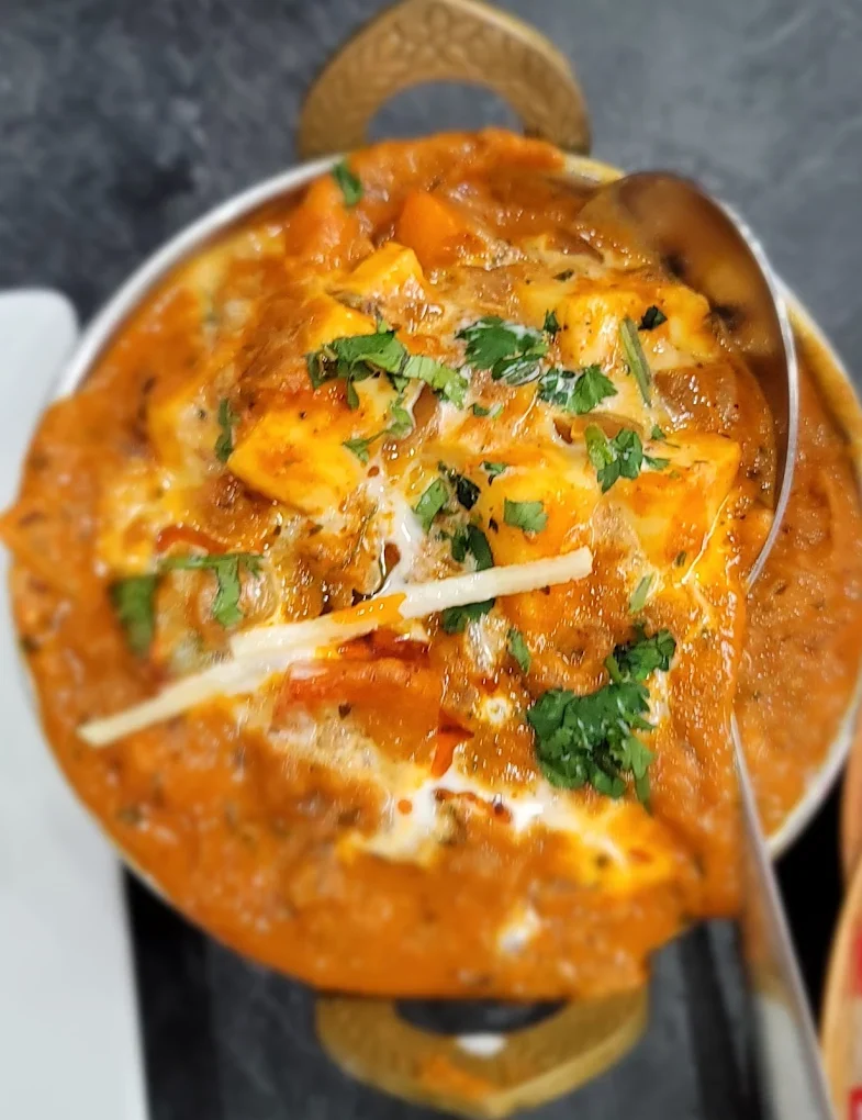 Rich paneer curry garnished with cilantro